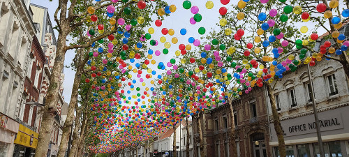 Nuée de ballons multicolores accrochés en travers du boulevard..